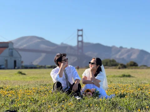 Nam-Hee and Hiroo in a wildflower field with the Golden Gate Bridge behind them.