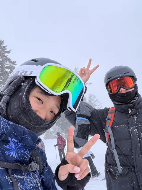Nam-Hee and Hiroo wearing helmets and goggles in the snow.